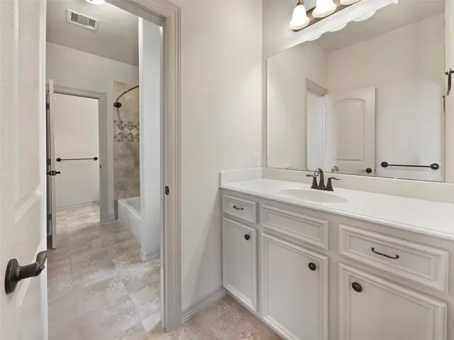 an empty room with windows and chandelier fan