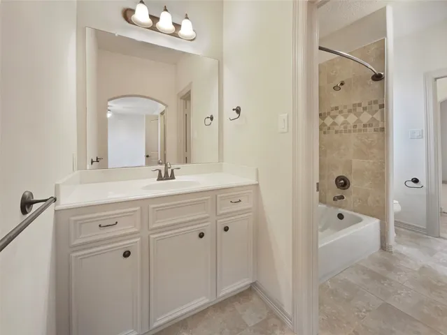 a spacious bathroom with double vanity a toilet a a mirror a bathtub and shower
