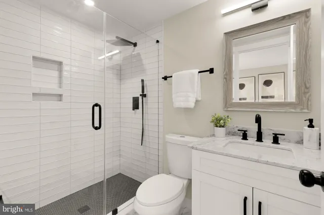 a bathroom with a sink toilet vanity and shower