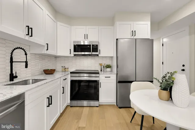 a kitchen with stainless steel appliances a stove refrigerator sink and cabinets
