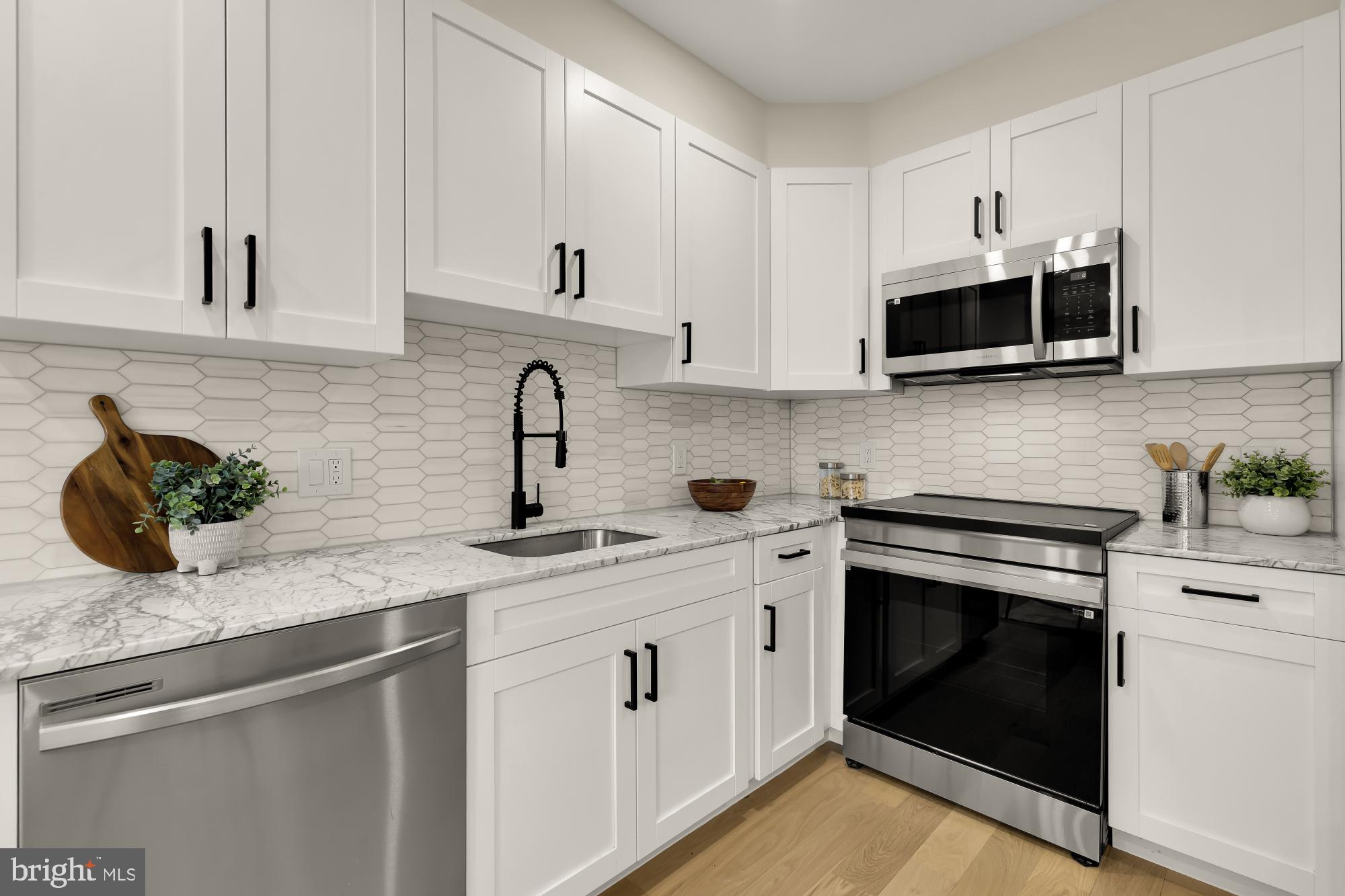 2606 41st Street Northwest, Unit 6 Washington, DC 20007 - Photo 9 of 25 a kitchen with stainless steel appliances granite countertop white cabinets a sink and dishwasher