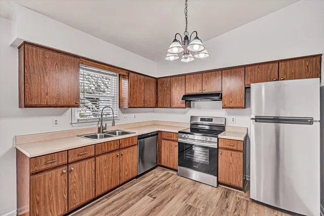 a kitchen with stainless steel appliances granite countertop a sink stove and refrigerator