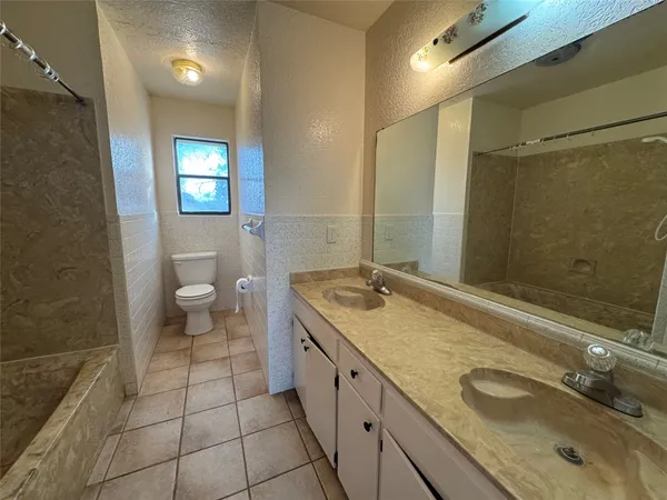 a spacious bathroom with a granite countertop sink toilet and shower