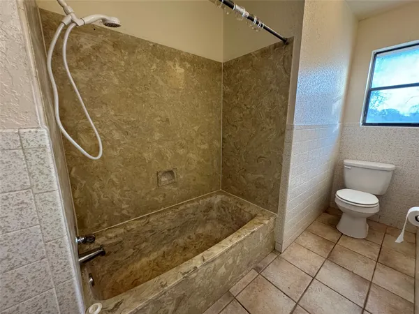 a bathroom with a toilet and shower