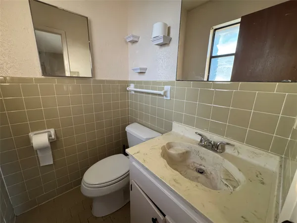 a bathroom with a sink a toilet a mirror and shower
