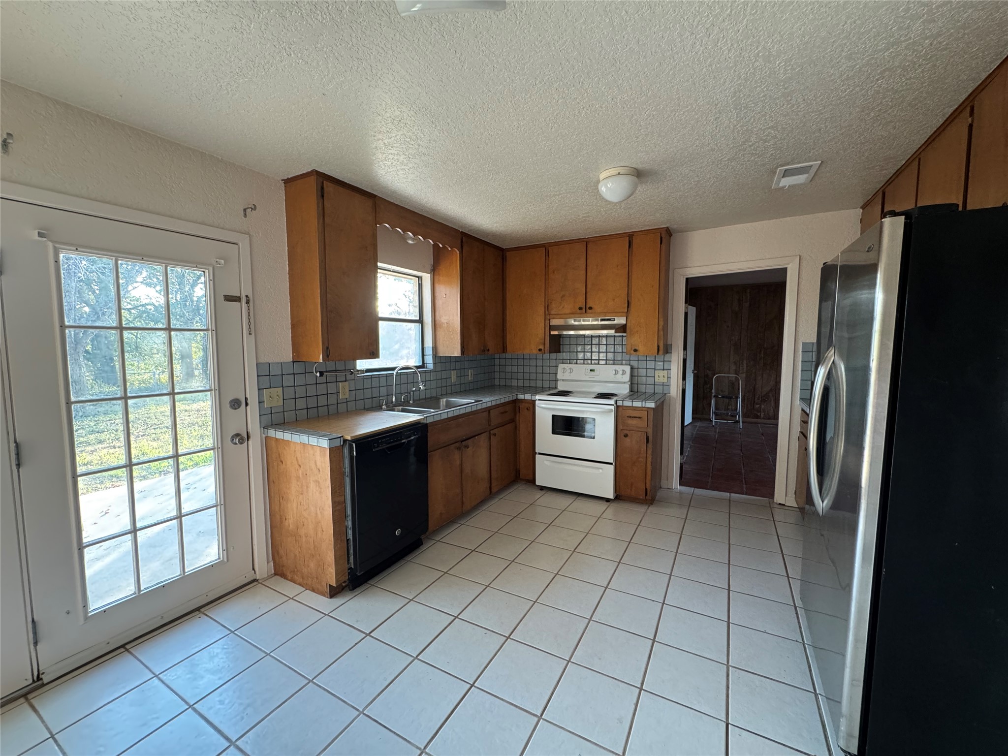 163 Robinson Road Lockhart, TX 78644 - Photo 5 of 21 a large kitchen with a stove a sink dishwasher a refrigerator and cabinets