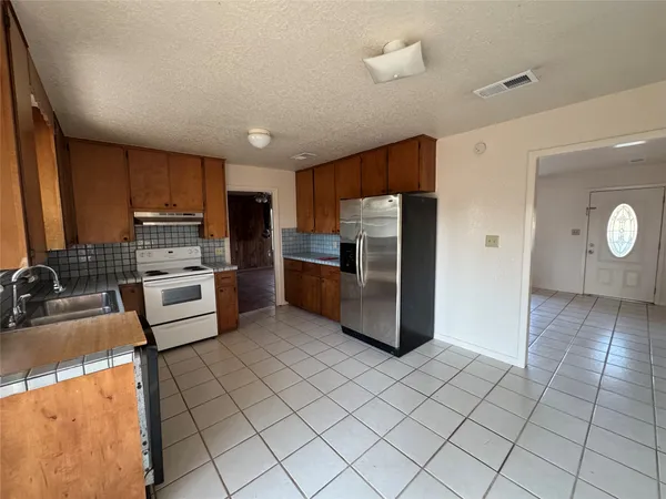 a kitchen with granite countertop a refrigerator and a sink