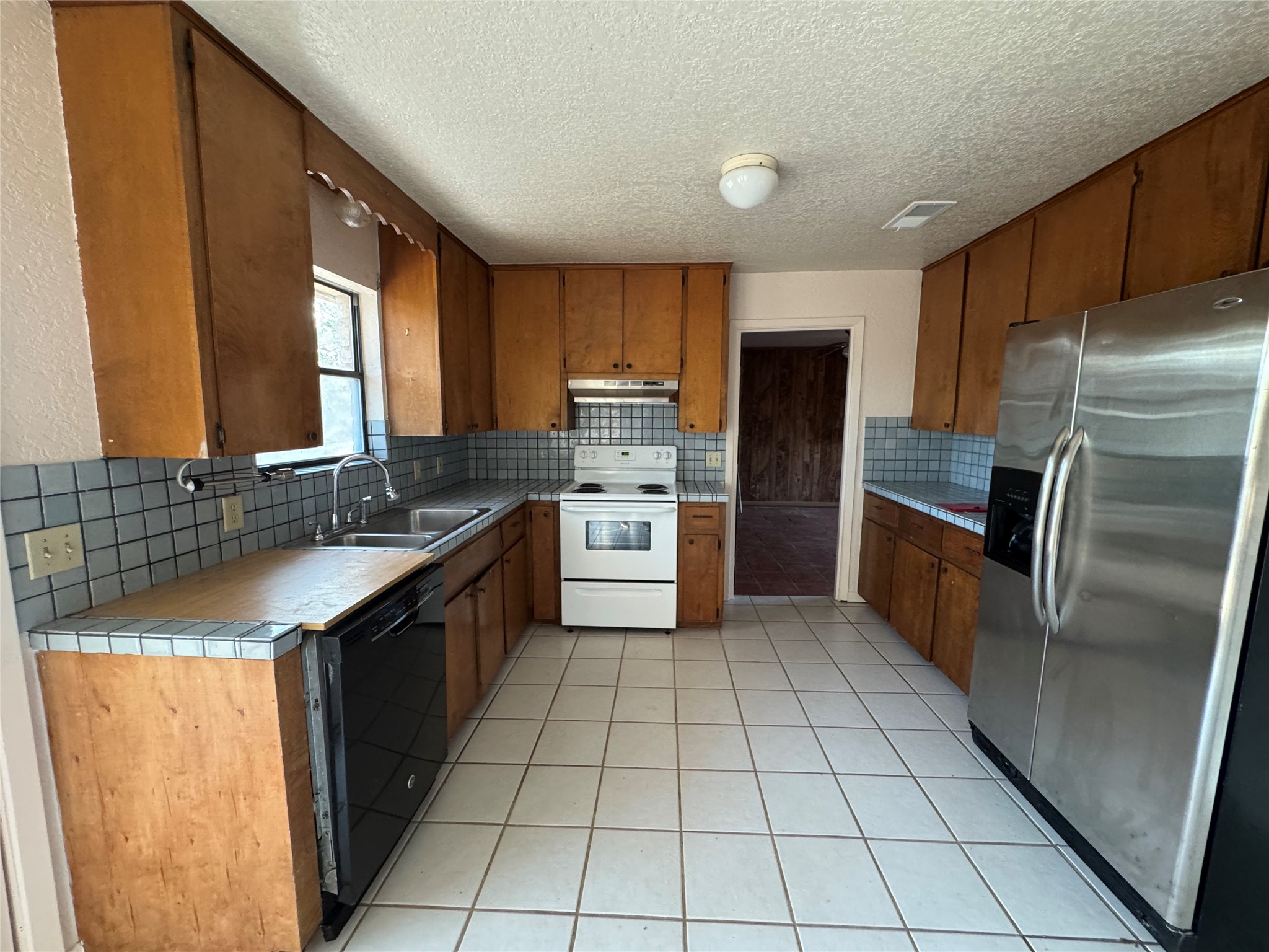 163 Robinson Road Lockhart, TX 78644 - Photo 7 of 21 a kitchen with stainless steel appliances granite countertop a sink stove and refrigerator