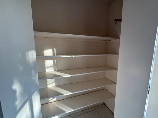 a view of walk in closet with empty racks