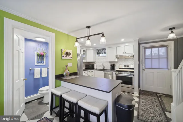 a kitchen with a dining table chairs and refrigerator