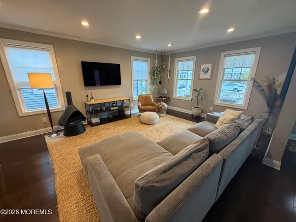 a living room with furniture a flat screen tv and wooden floor