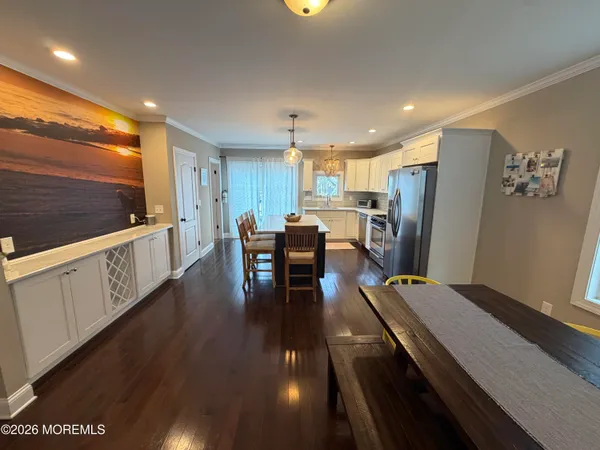 a kitchen with stainless steel appliances refrigerator dining table and chairs