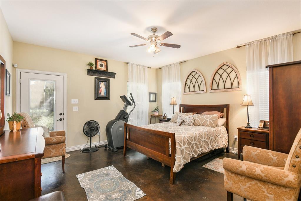 203 Saddle Ridge Court Springtown, TX 76082 - Photo 19 of 34 a bedroom with a bed and a chandelier