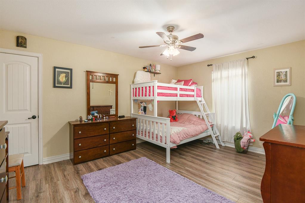 203 Saddle Ridge Court Springtown, TX 76082 - Photo 23 of 34 a bedroom with a bed and wooden floor