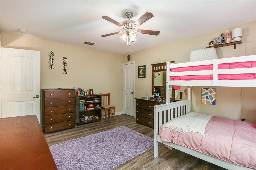 203 Saddle Ridge Court Springtown, TX 76082 - Photo 24 of 34 a bedroom with a bed and wooden floor
