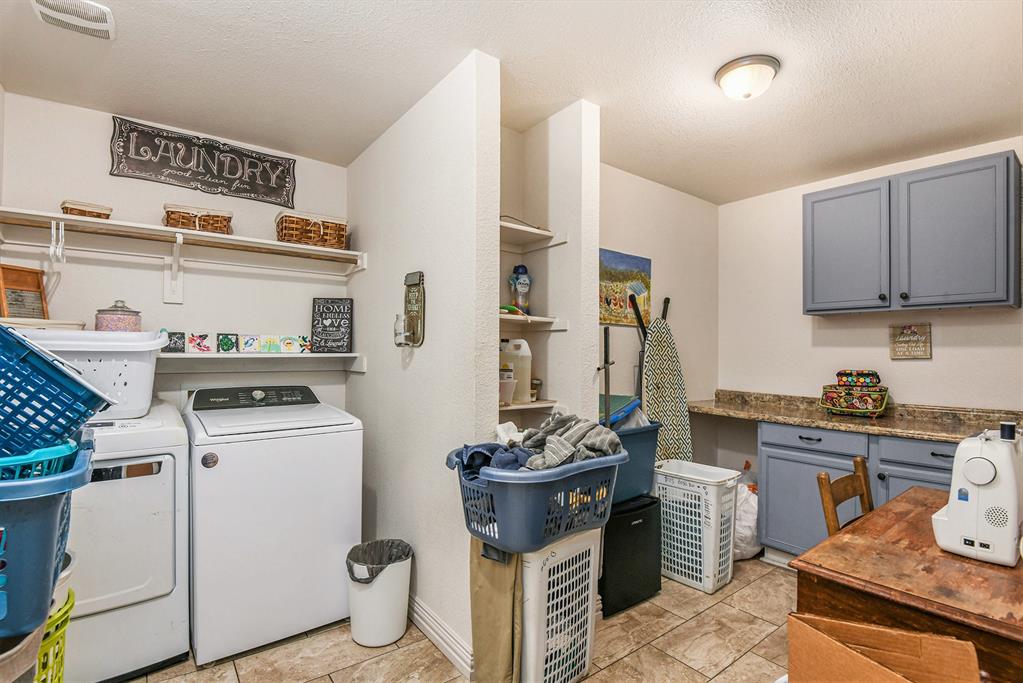 203 Saddle Ridge Court Springtown, TX 76082 - Photo 29 of 34 a kitchen with a stove and a refrigerator