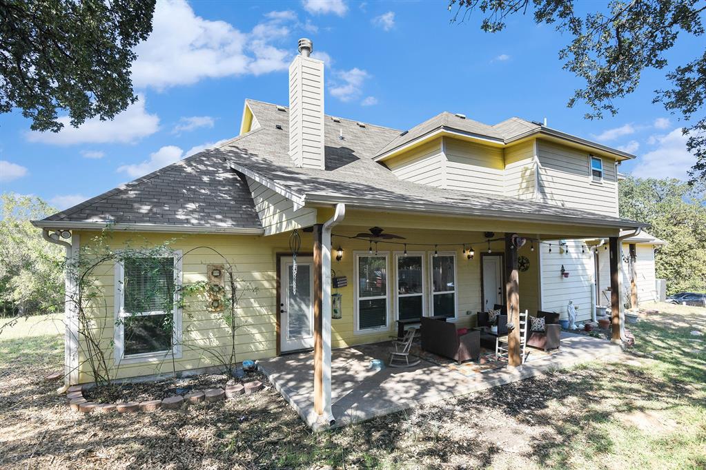 203 Saddle Ridge Court Springtown, TX 76082 - Photo 30 of 34 a view of a house with sitting area and garden