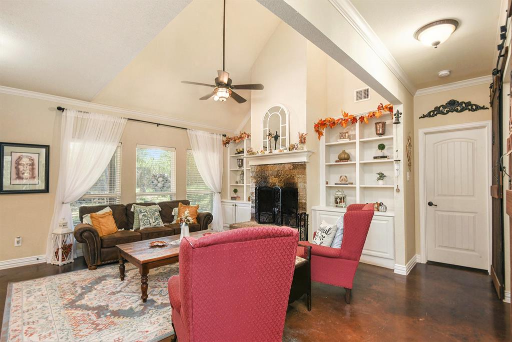 203 Saddle Ridge Court Springtown, TX 76082 - Photo 5 of 34 a living room with furniture a fireplace and a large window