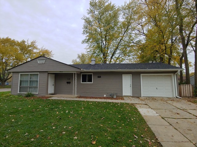 a front view of a house with a garden and yard