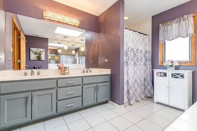 a bathroom with a double vanity sink mirror and