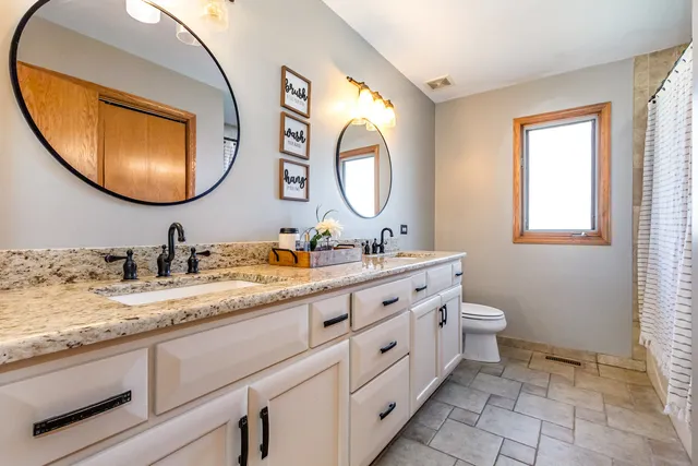 a bathroom with 2 sink and a mirror