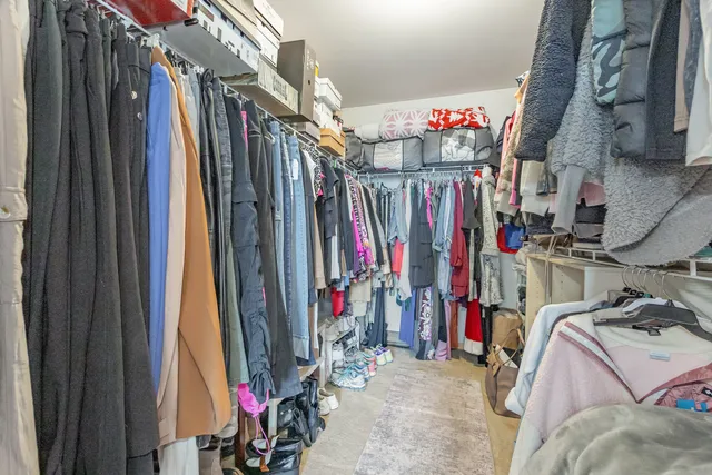 a view of walk in closet with clothes