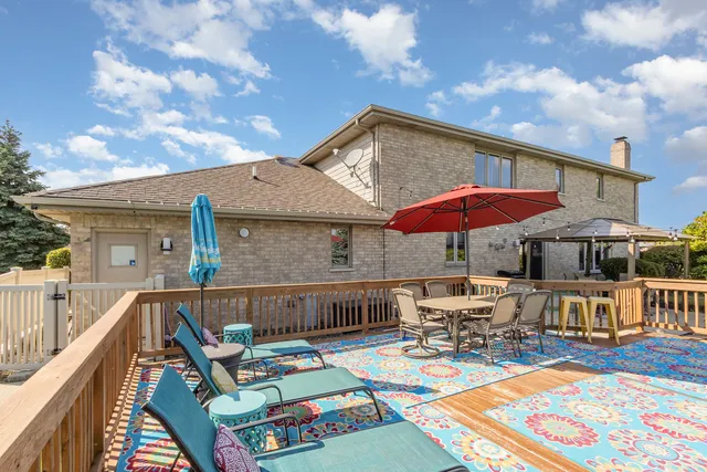 a roof deck with table and chairs under an umbrella