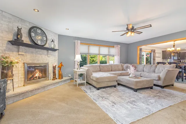 a living room with furniture a clock and a fireplace