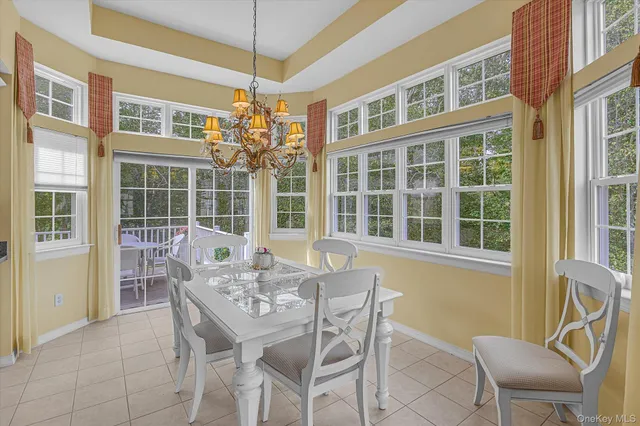 a dining room with furniture large windows and wooden floor