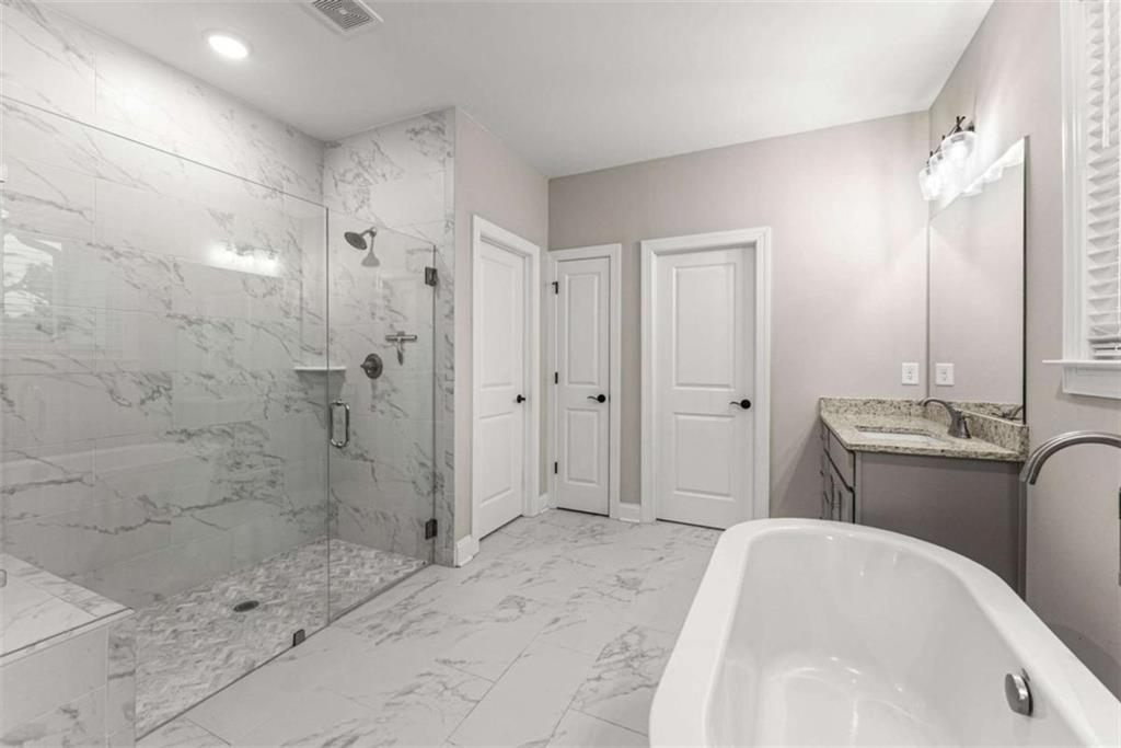 876 Sweetgrass Drive Demorest, GA 30535 - Photo 27 of 56 a spacious bathroom with a granite countertop sink a toilet a mirror and shower