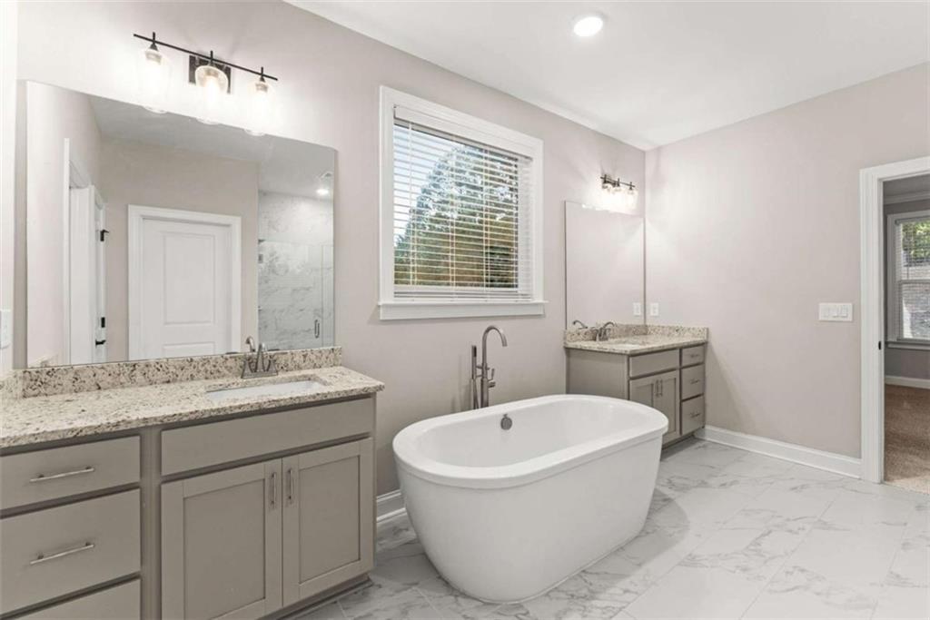 876 Sweetgrass Drive Demorest, GA 30535 - Photo 28 of 56 a bathroom with a granite countertop sink mirror and a bathtub