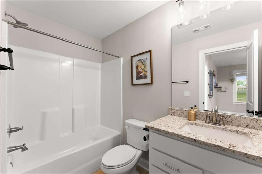 876 Sweetgrass Drive Demorest, GA 30535 - Photo 36 of 56 a bathroom with a granite countertop sink mirror vanity toilet and bathtub