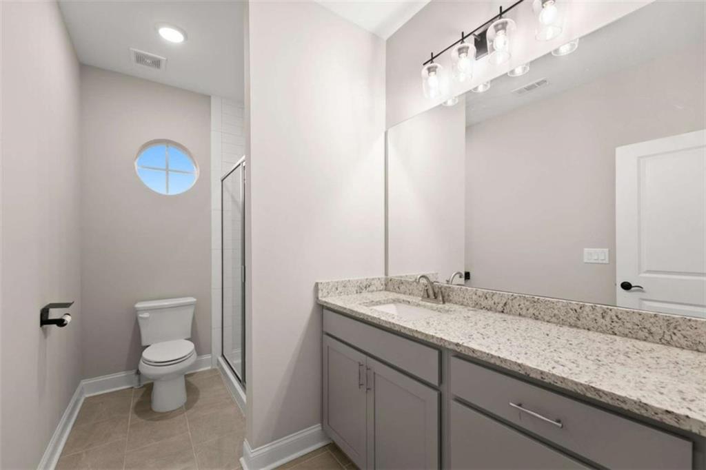876 Sweetgrass Drive Demorest, GA 30535 - Photo 4 of 56 a bathroom with a granite countertop sink toilet and a mirror