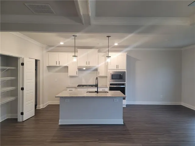 a kitchen with kitchen island a sink stainless steel appliances and cabinets