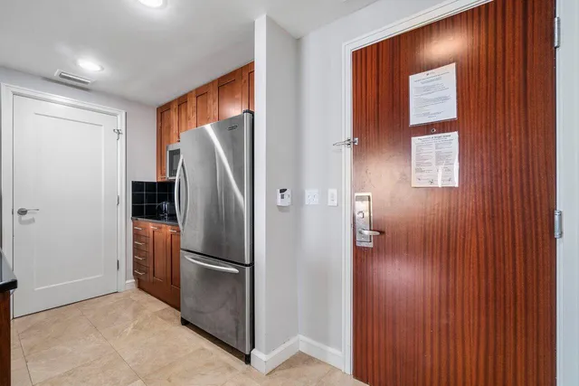 a view of kitchen with stainless steel appliances wooden floor and window