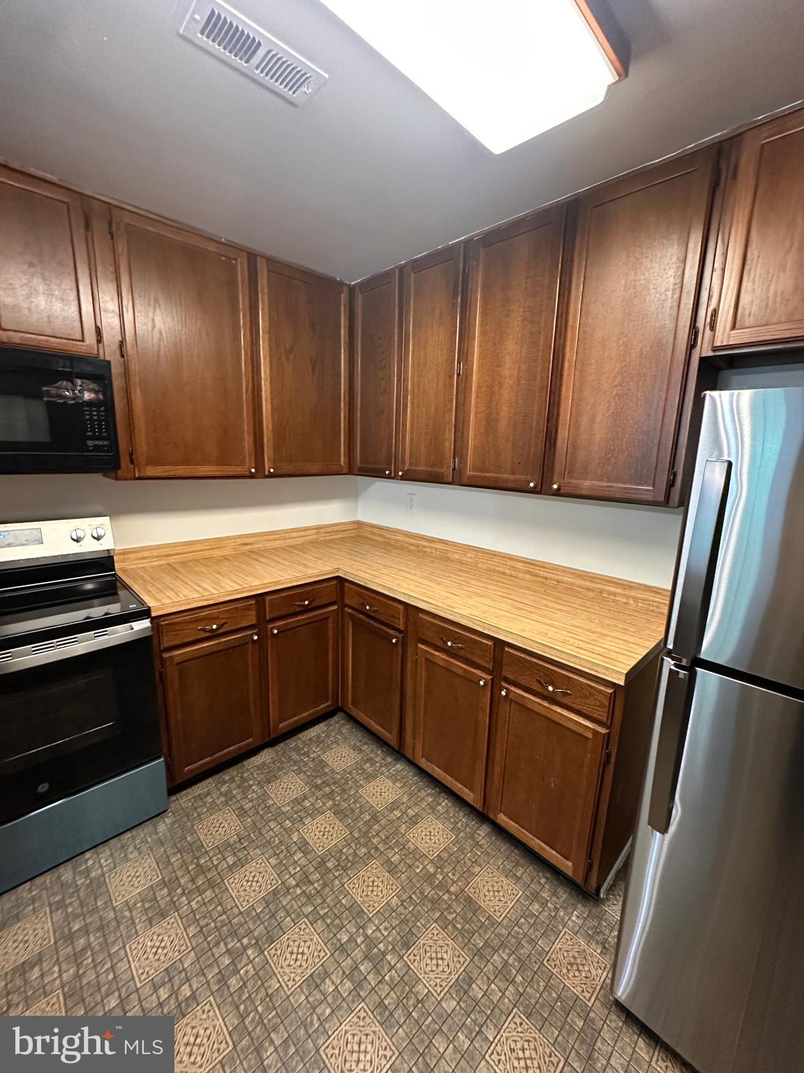 6937 Mayfair Terrace Laurel, MD 20707 - Photo 13 of 36 a kitchen with stainless steel appliances granite countertop wood cabinets and a stove top oven