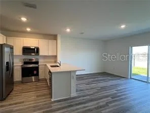 a kitchen with a refrigerator and a stove top oven