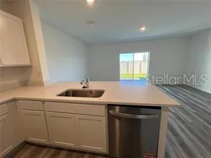 a kitchen with a sink cabinets and wooden floor