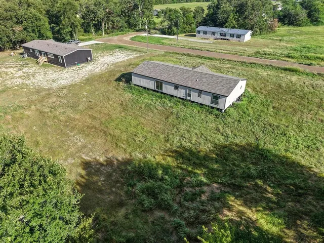 a view of a backyard with lawn chairs and plants