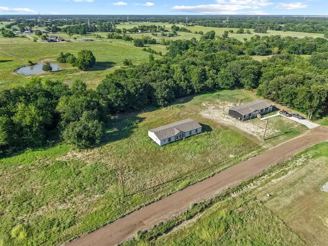 a view of a lush green field with lots of green plants in front of it