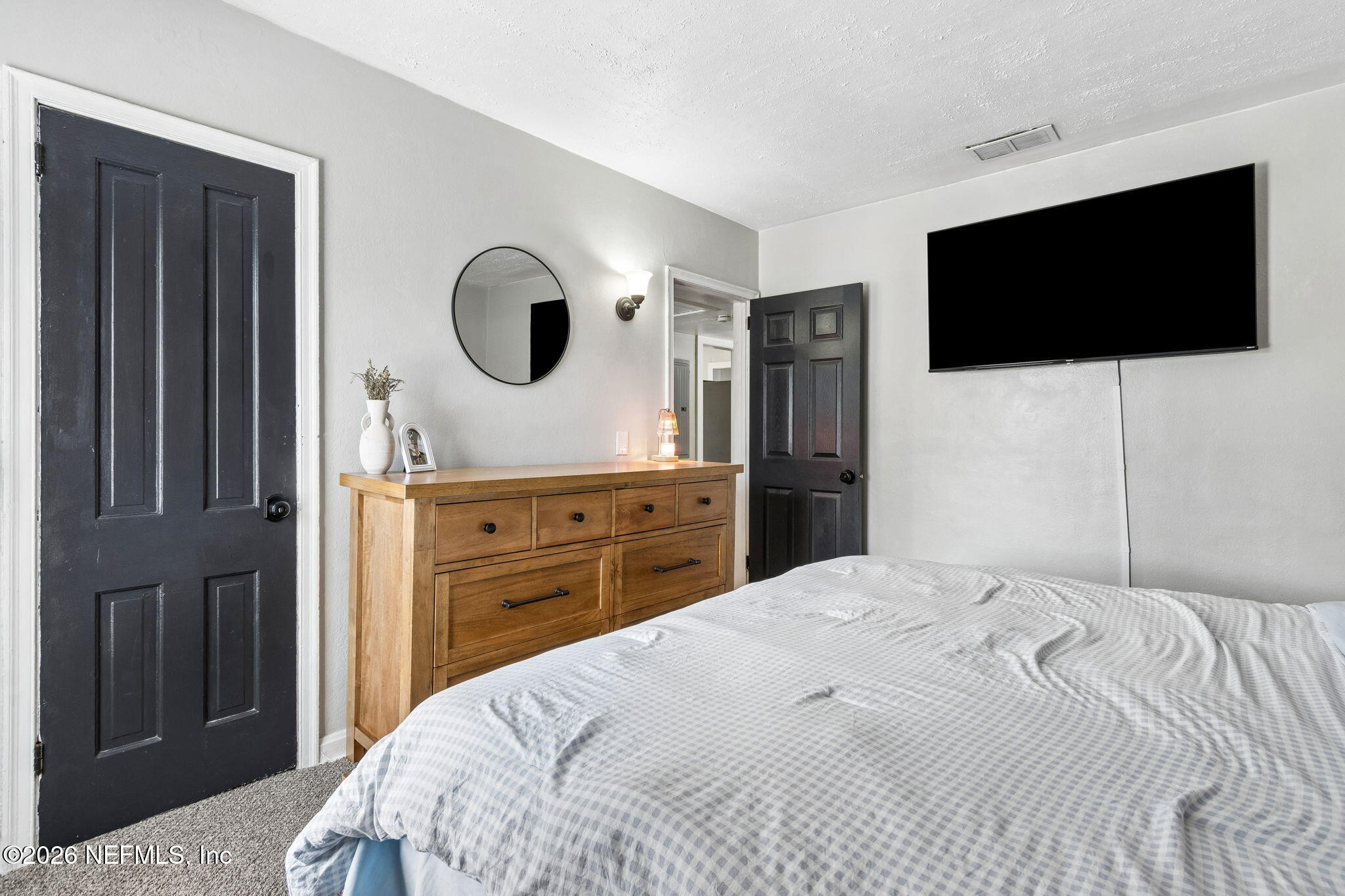 4816 Riverdale Road Jacksonville, FL 32210 - Photo 18 of 49 a bedroom with a bed and a flat screen tv