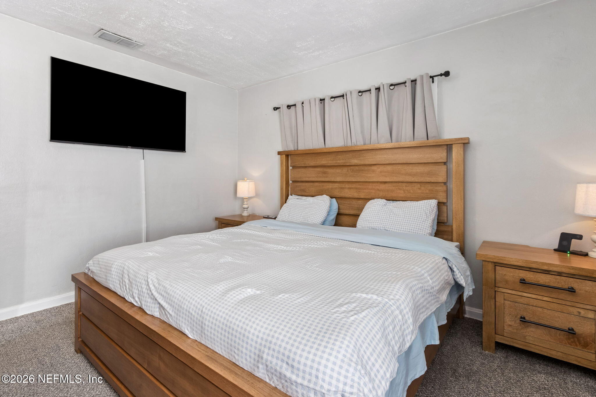 4816 Riverdale Road Jacksonville, FL 32210 - Photo 19 of 49 a bedroom with a bed and a flat screen tv