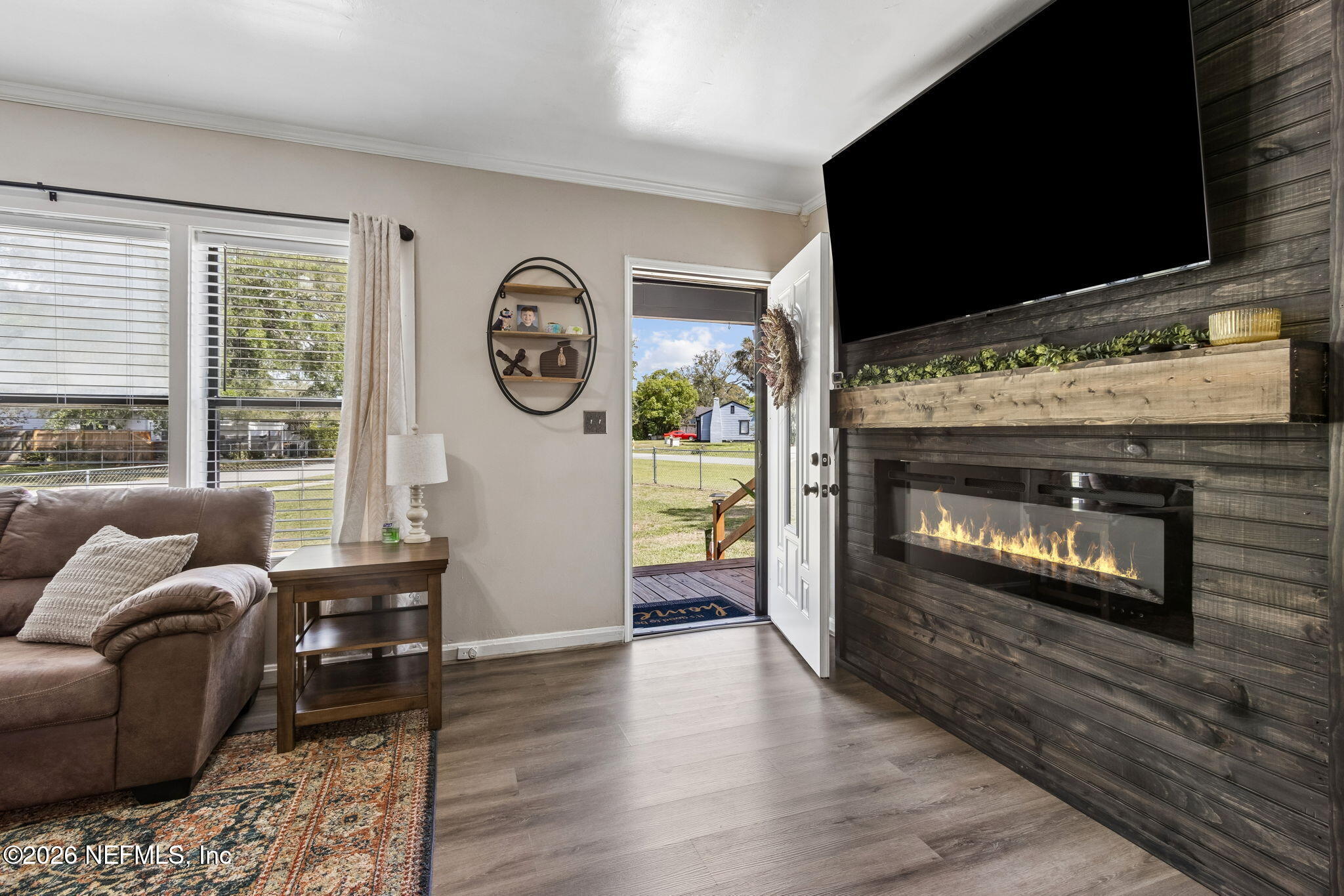 4816 Riverdale Road Jacksonville, FL 32210 - Photo 4 of 49 a living room with furniture a fireplace and a flat screen tv