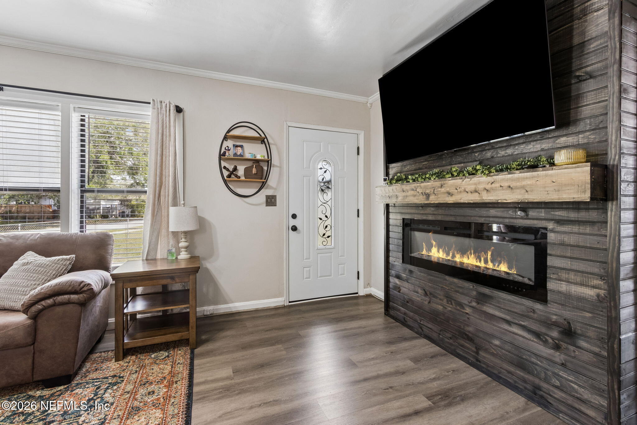4816 Riverdale Road Jacksonville, FL 32210 - Photo 5 of 49 a living room with furniture a fireplace and a flat screen tv