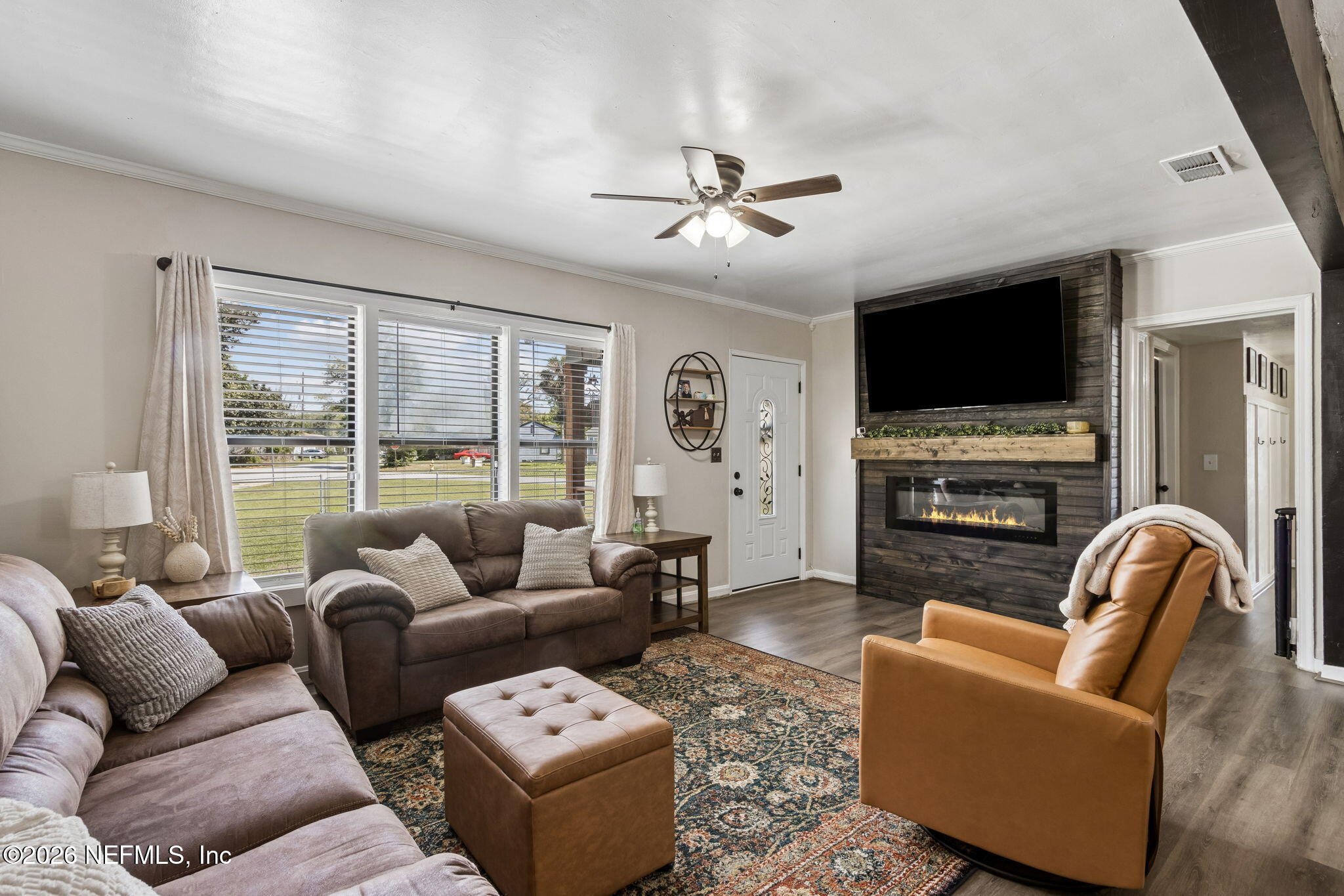 4816 Riverdale Road Jacksonville, FL 32210 - Photo 7 of 49 a living room with furniture a flat screen tv and a fireplace