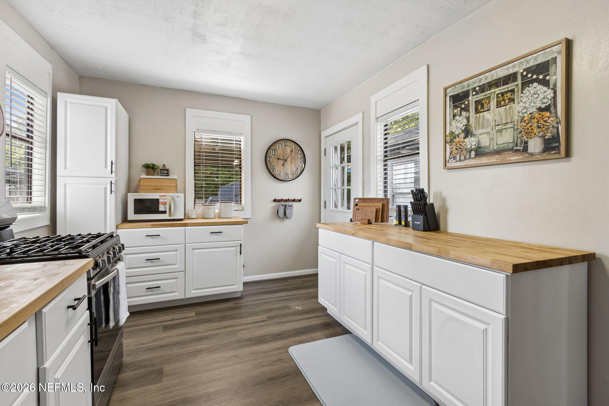 4816 Riverdale Road Jacksonville, FL 32210 - Photo 8 of 49 a kitchen with white cabinets and wooden floor