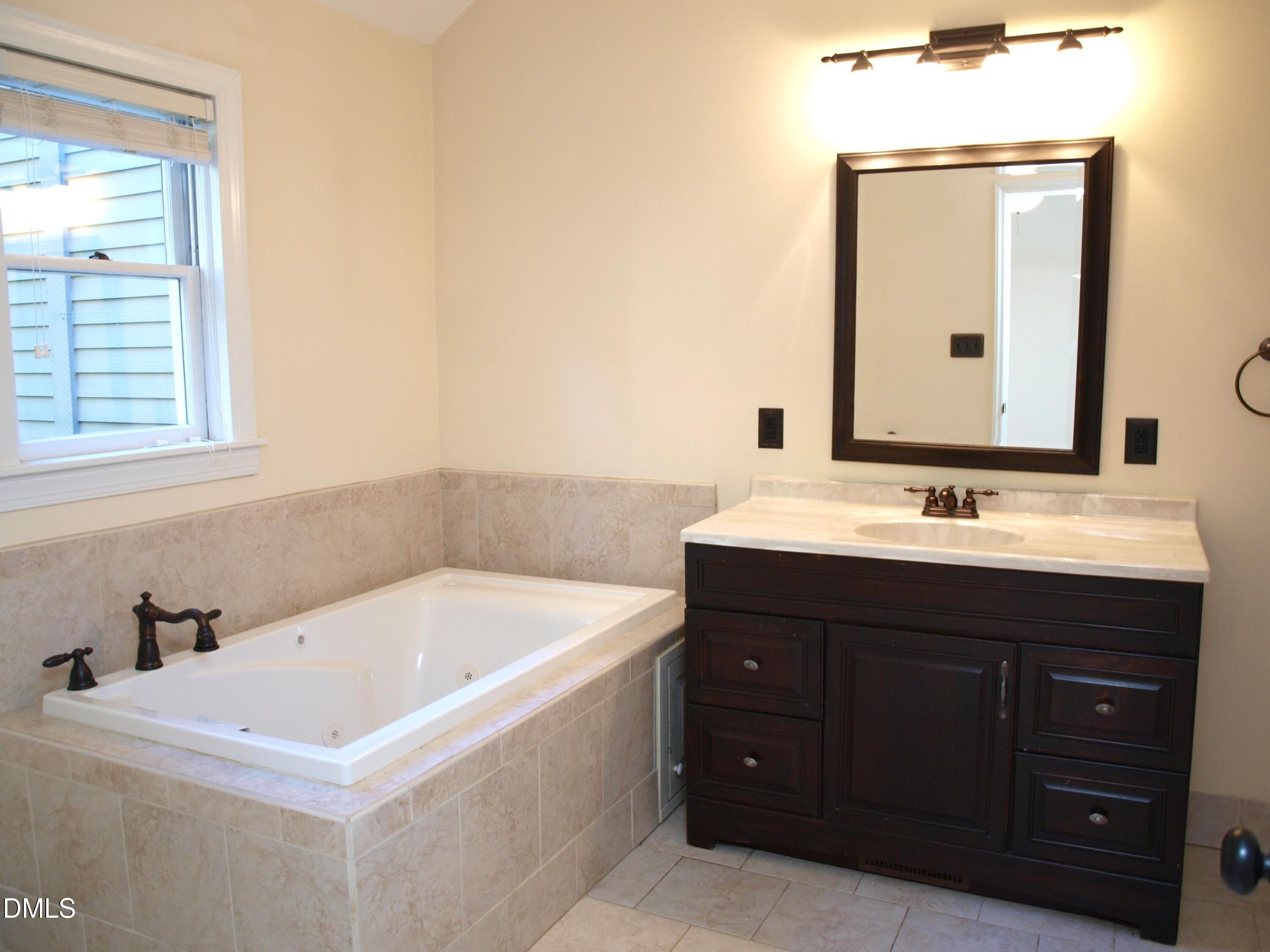 1707 Falls Church Road Raleigh, NC 27609 - Photo 13 of 22 a bathroom with a sink and a mirror