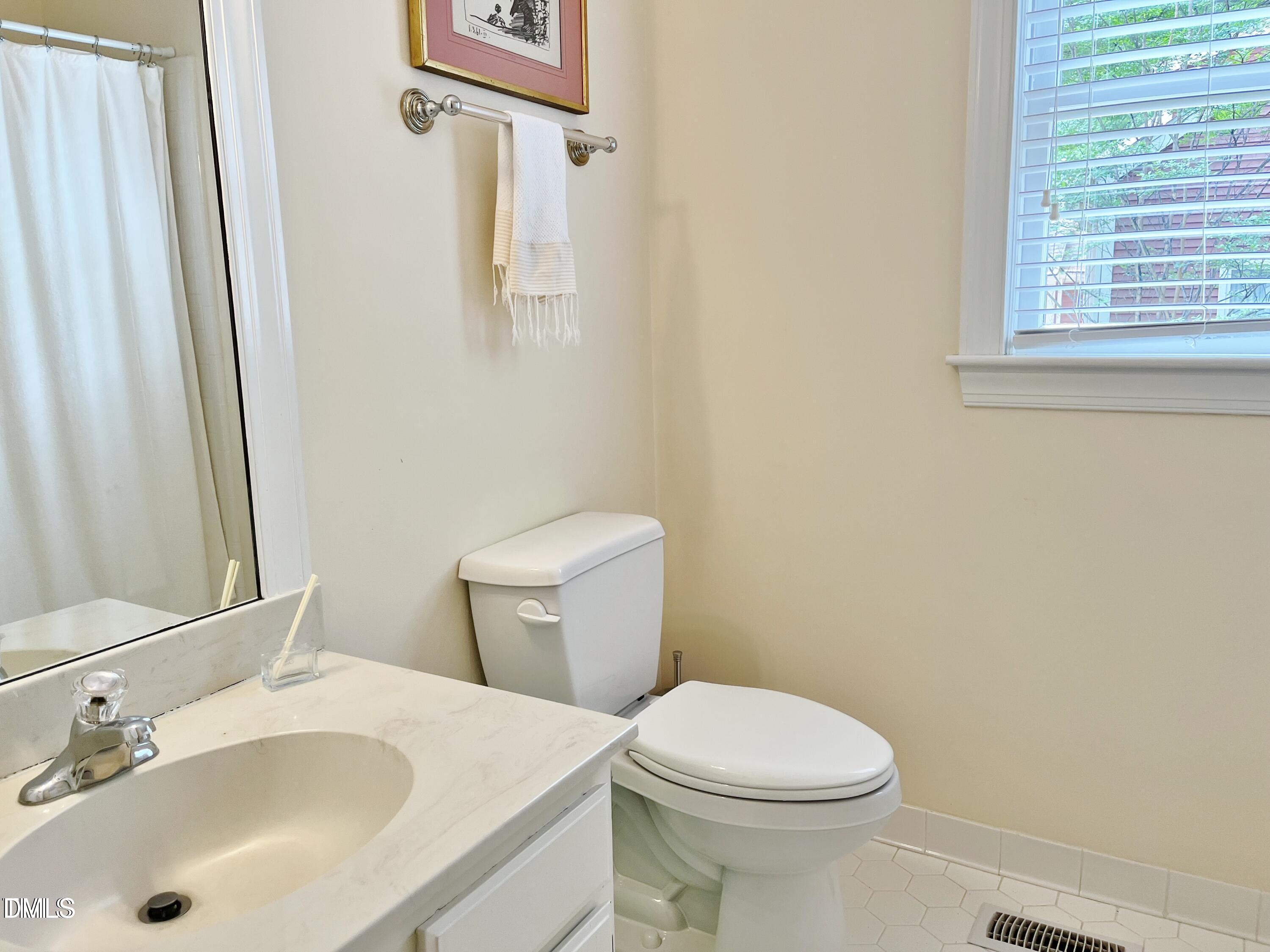 1707 Falls Church Road Raleigh, NC 27609 - Photo 15 of 22 a bathroom with a sink a toilet and a mirror