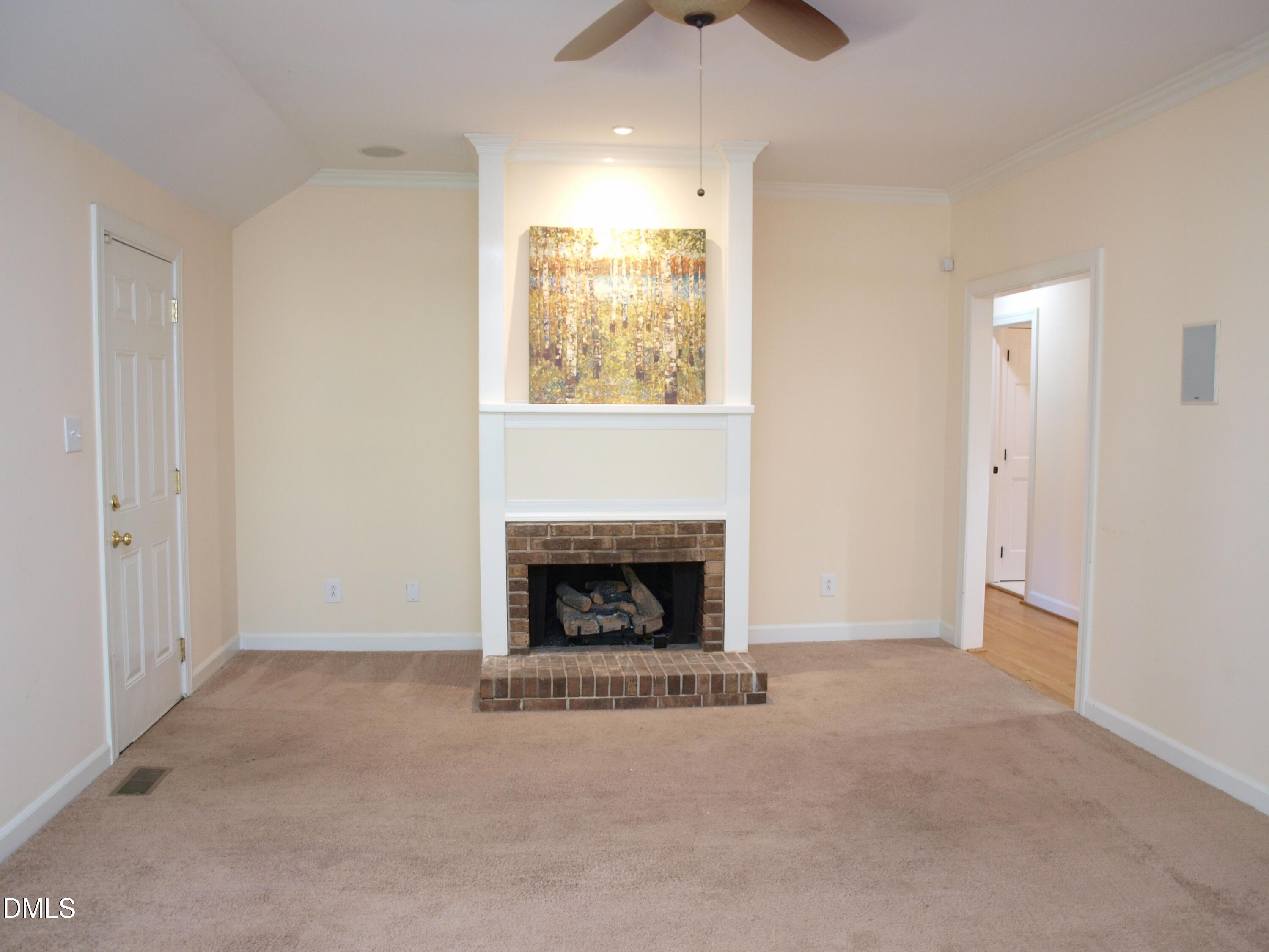 1707 Falls Church Road Raleigh, NC 27609 - Photo 3 of 22 a view of an empty room with a fireplace and a window