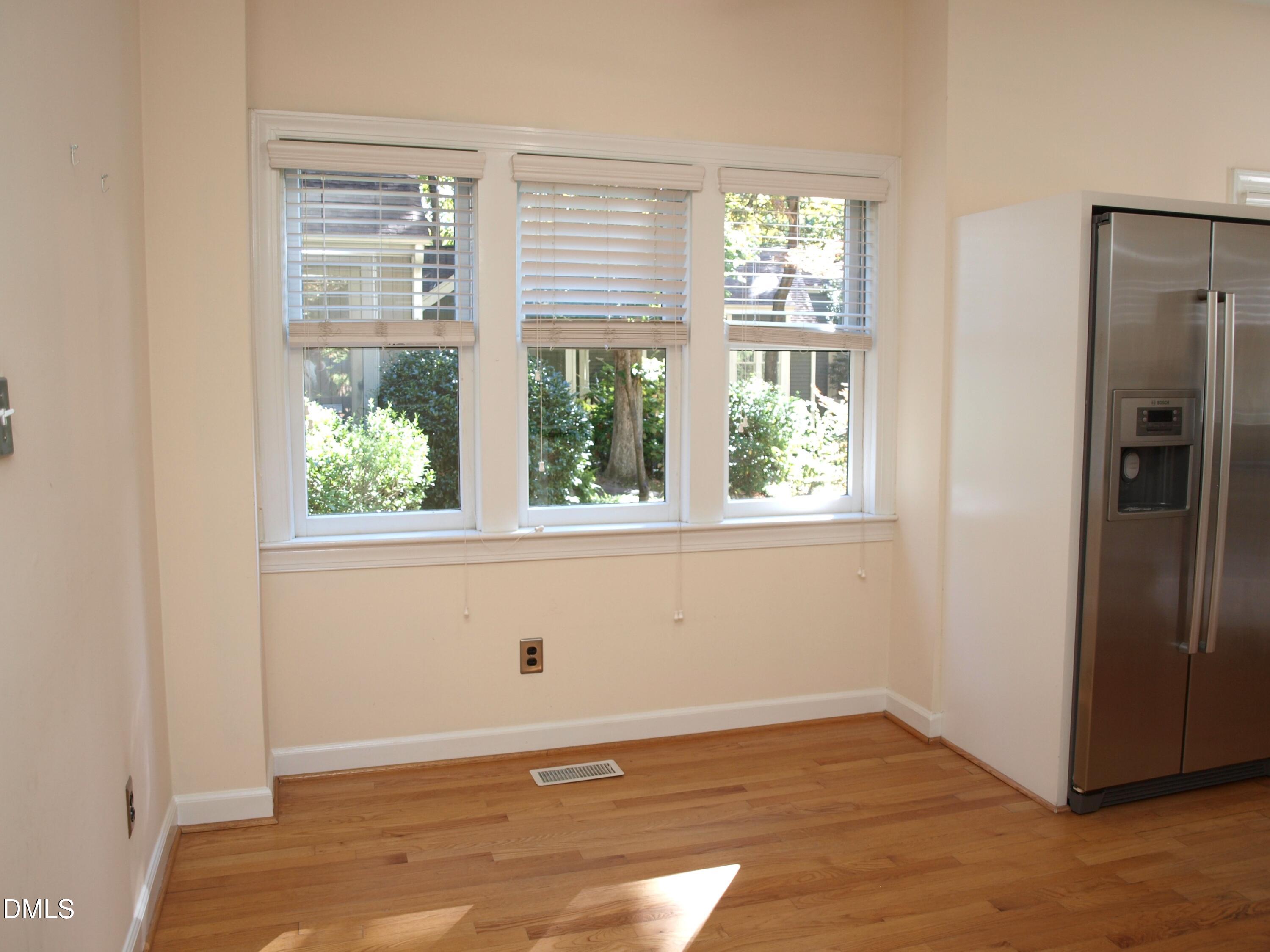 1707 Falls Church Road Raleigh, NC 27609 - Photo 7 of 22 an empty room with wooden floor and windows